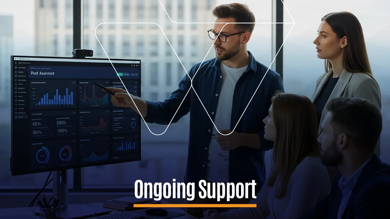 Team in an office meeting while a man presents analytics on a large screen, discussing charts and graphs under the heading ‘Ongoing Support.